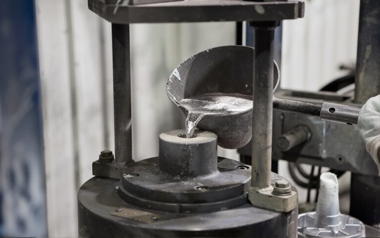Die casting process pouring molten metal into a machine mold